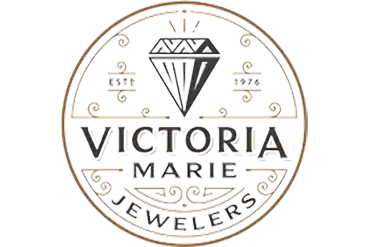 Logo of Victoria Marie Jewelers featuring a diamond above text, with decorative gold accents and ring design.