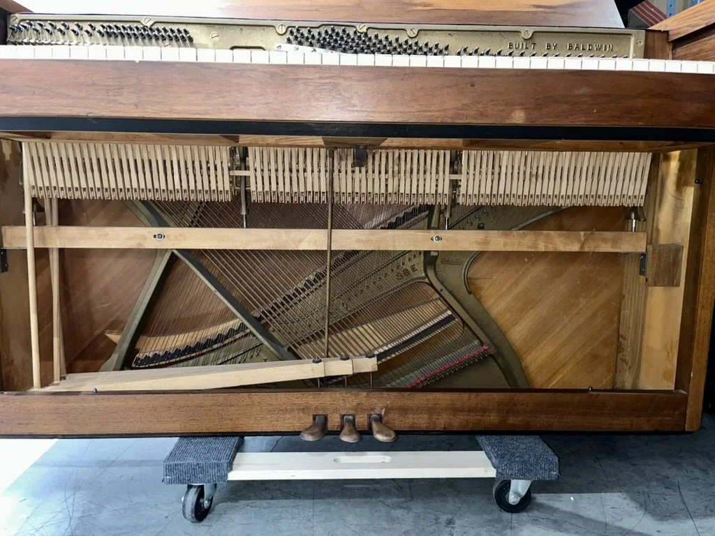 View of the drop-action in the Baldwin Scandinavian Natural Walnut 947 Acrosonic. Here you can see the action that is normally above the keyboard in larger uprights is below.