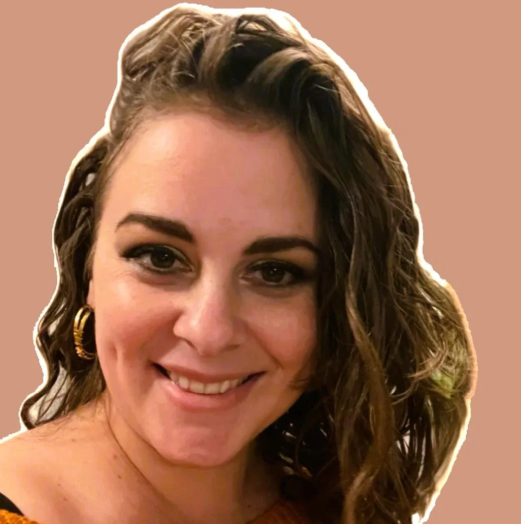 Attorney Monica Tulchinsky with curly brown hair, gold hoop earrings, and makeup smiling at the camera, against a plain background.