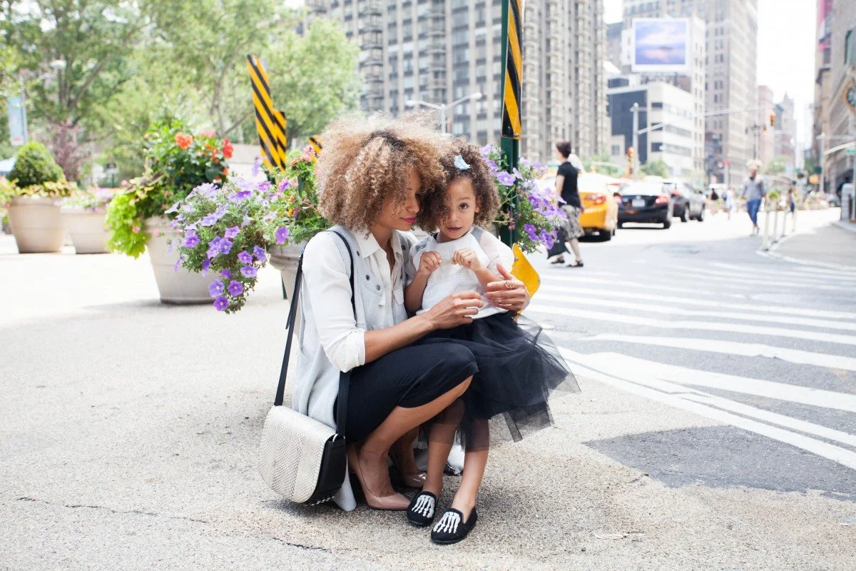 - oman comforting child on city sidewalk beside flowers, highlighting single mothers’ economic challenges. Would you like me to organize all your alt texts into a downloadable accessibility set or format them for your NPO site’s HTML?
