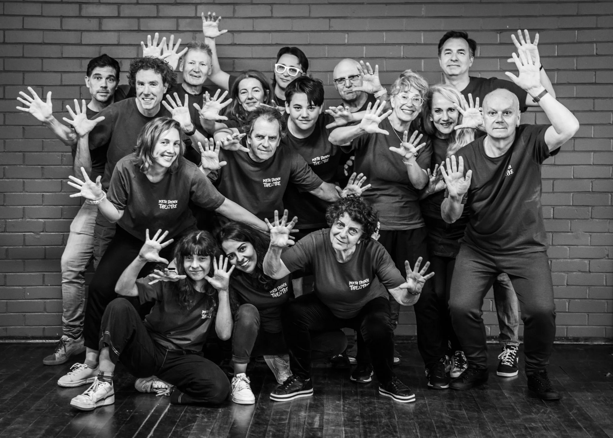 Perth French Theatre performers posing together in a black-and-white group portrait.