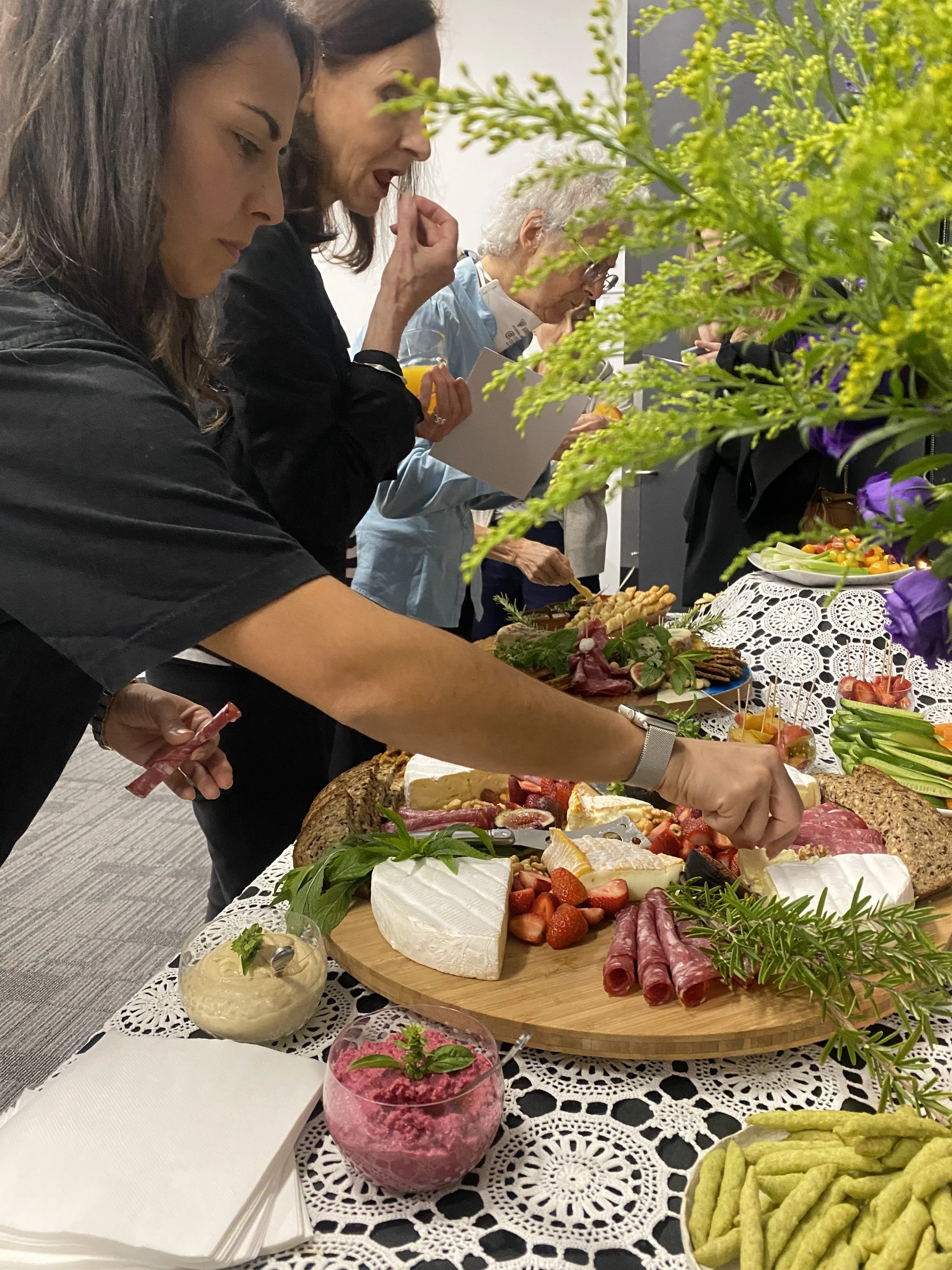 Guests serving food from a shared buffet table at a WAFF Collective gathering.