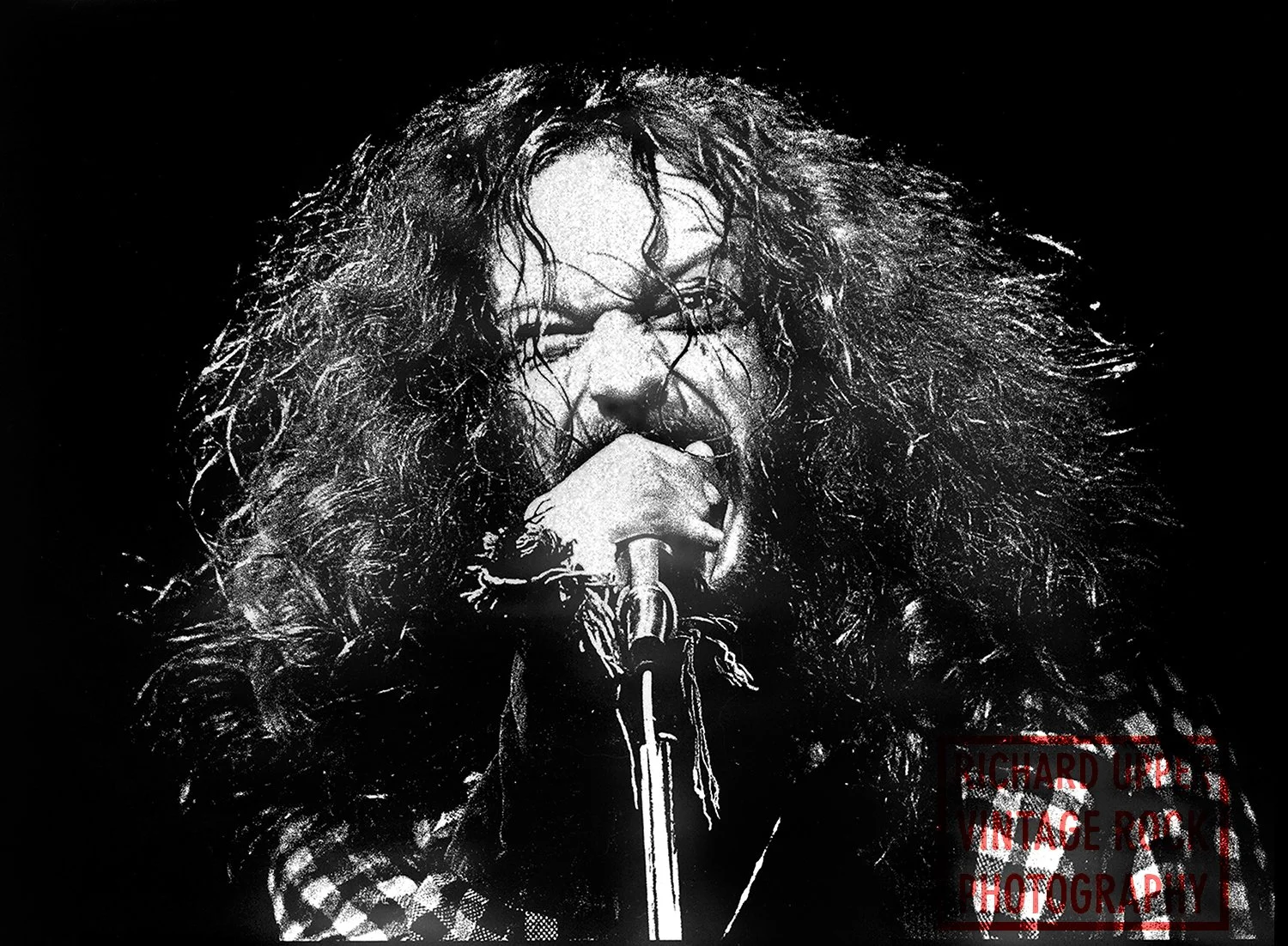 Black and white photo of a rock singer with long hair singing into a microphone. Text overlay reads "Richard Uppert Vintage Rock Photography."
