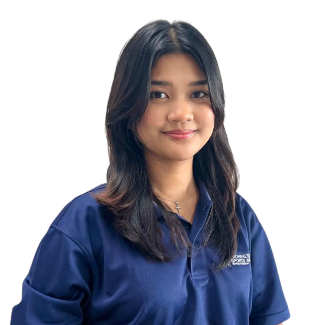 A young woman with shoulder-length black hair, wearing a navy blue collared shirt with a small logo, and a silver cross necklace, smiling against a plain white background.