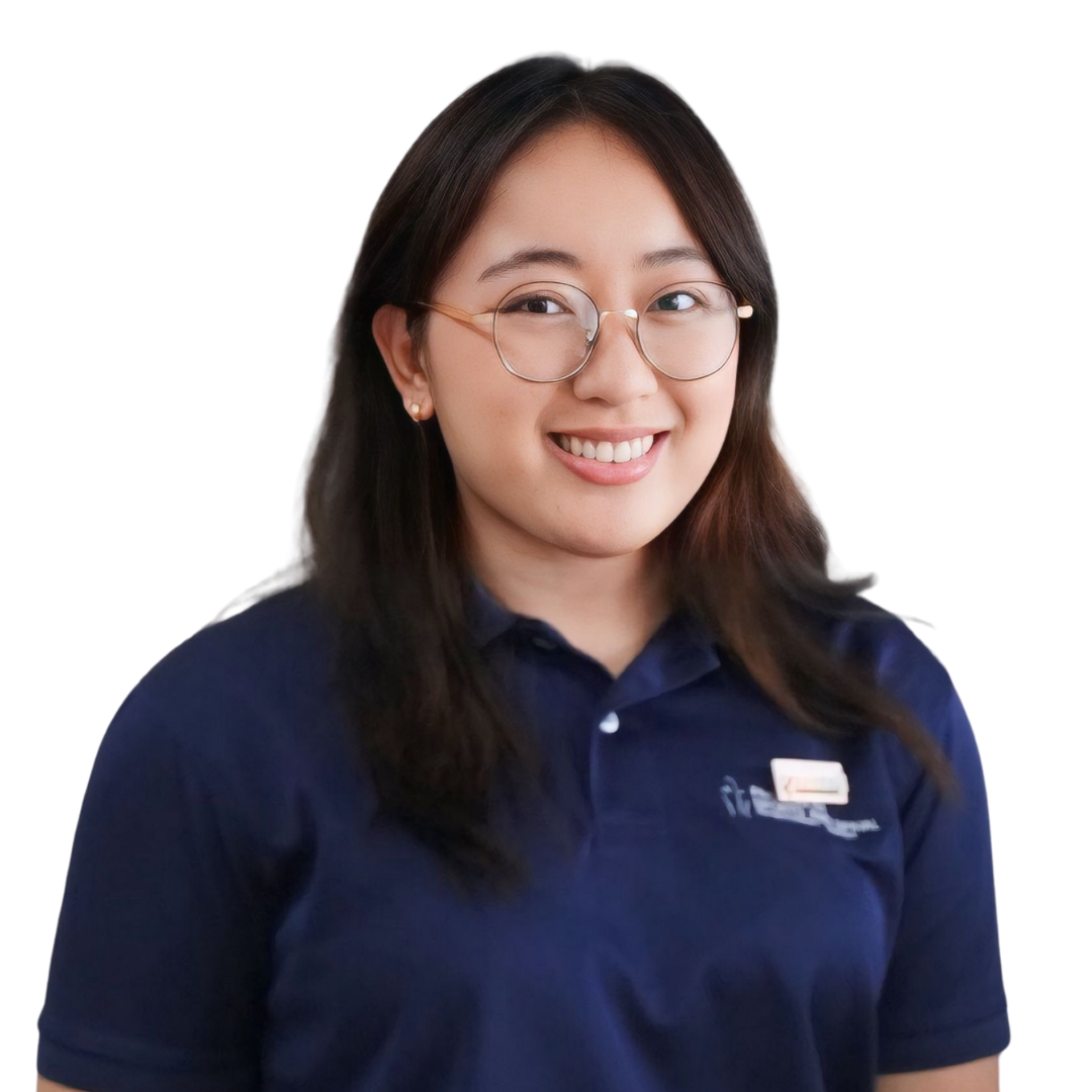 A young woman with glasses and long dark hair smiling, wearing a navy blue polo shirt with a name badge, against a white background.