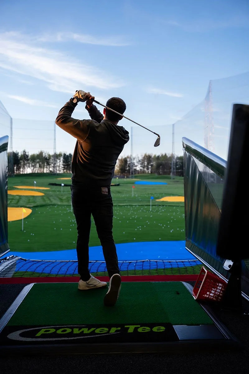 Silhouette of man playing golf at driving range