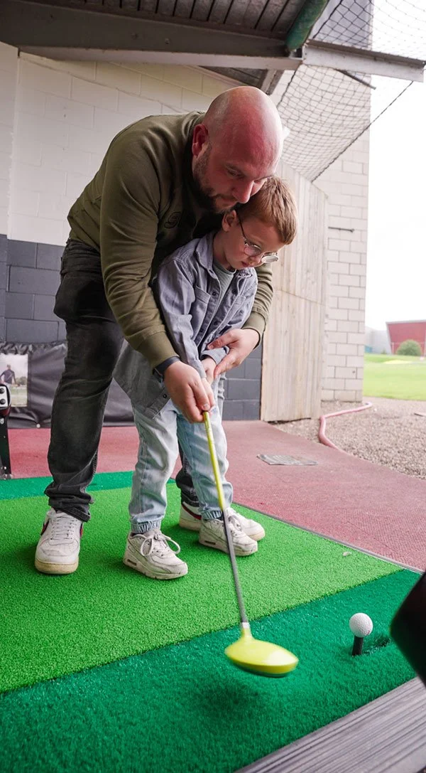 Father and son practising golf