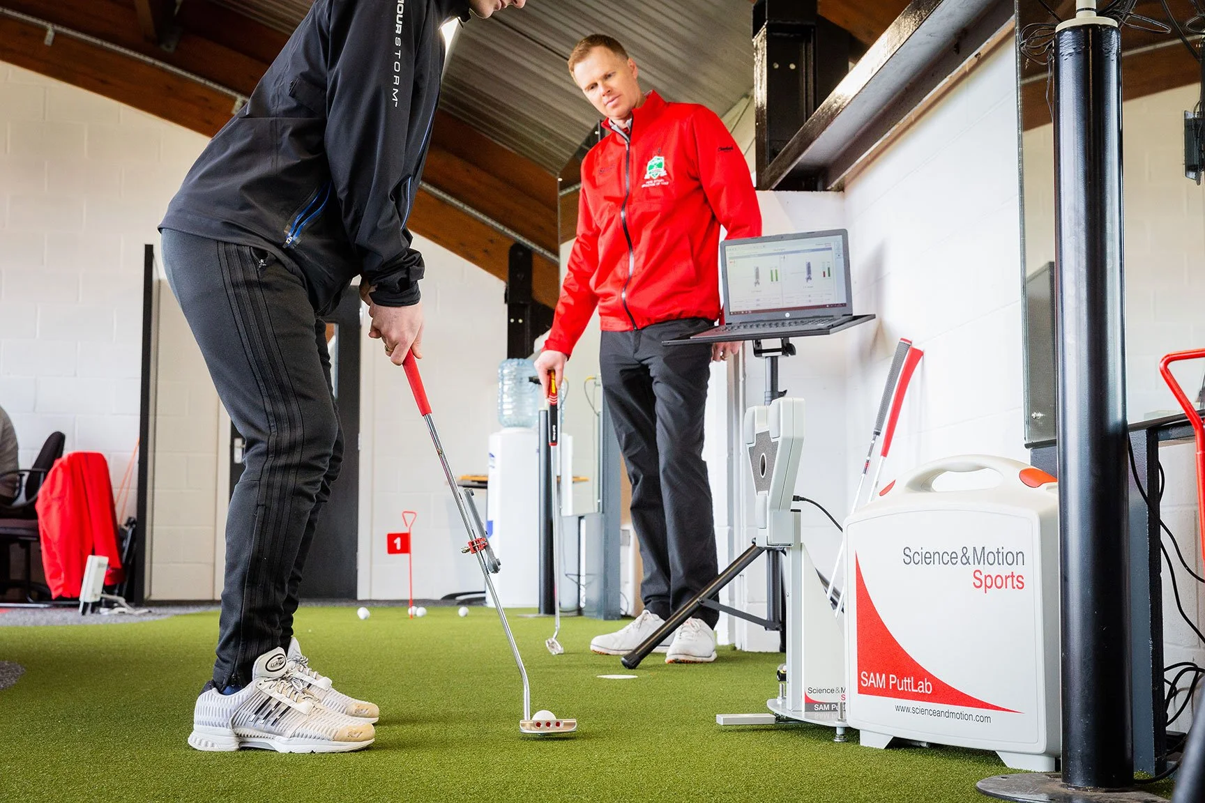 Golf pro watching client tee up