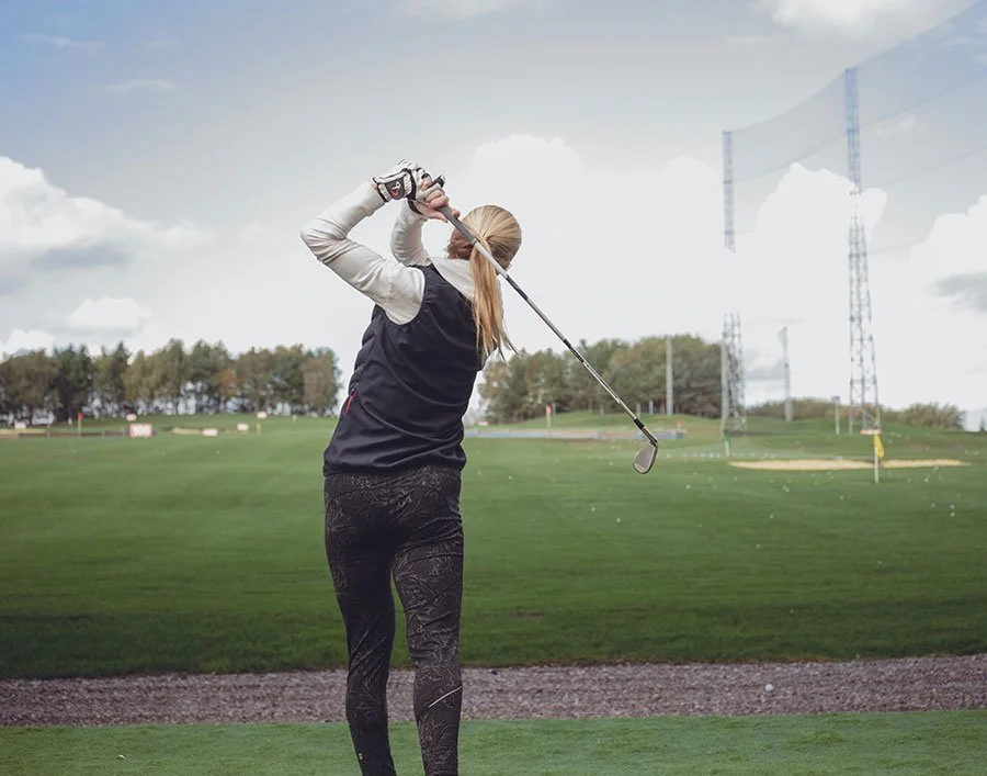 Woman playing golf at driving range