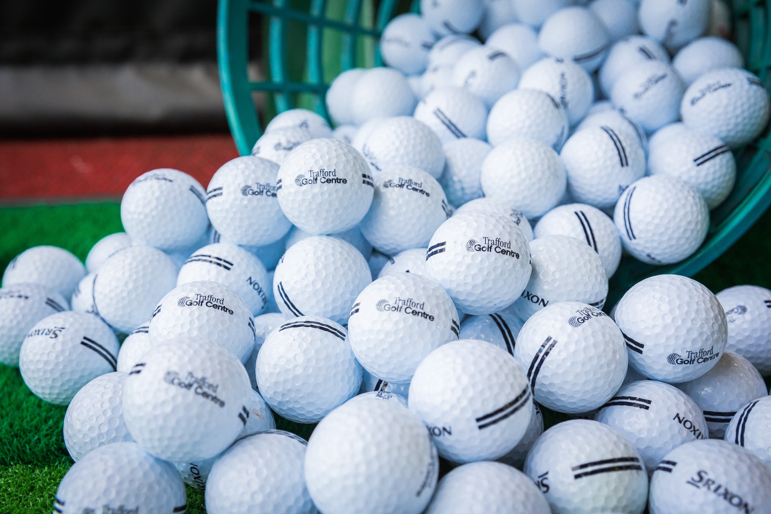 Basket of balls with golf clubs and a Budweiser
