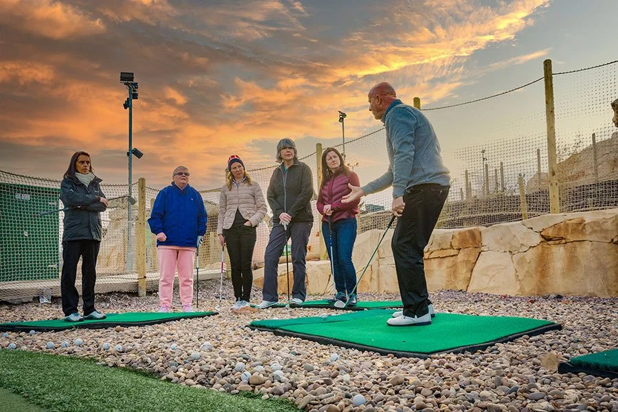 Group of 5 people watching a Golf Coach