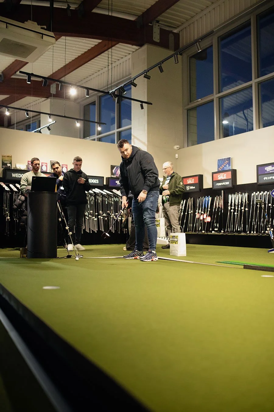 People playing golf inside American Golf