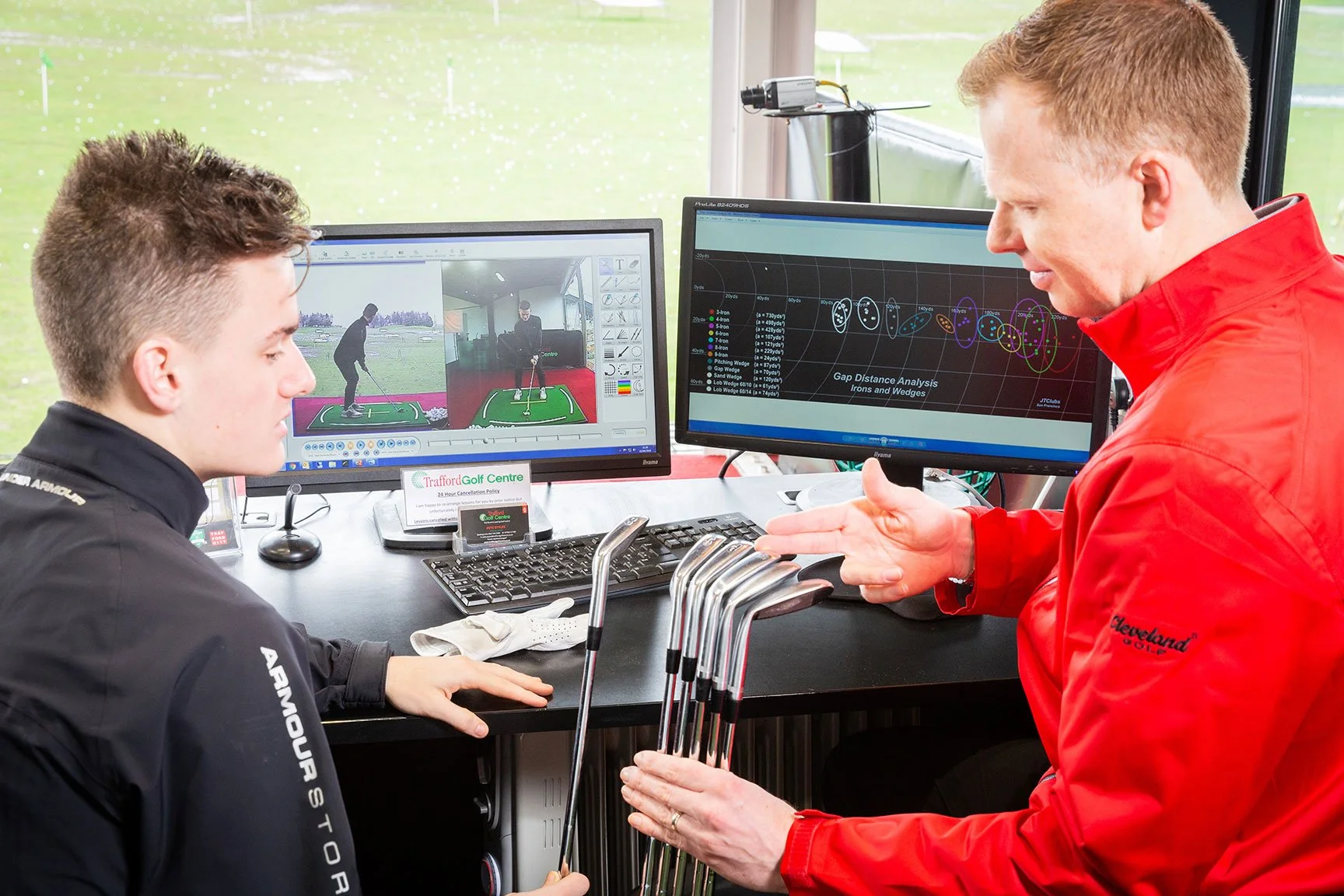 Golf pro showing clubs to client