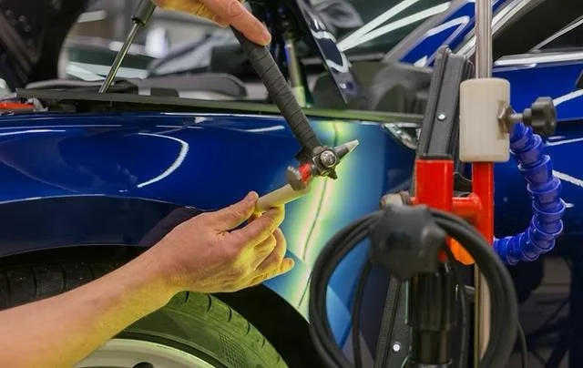 Bir otomobilin kaporta boyası yapılırken lazerle detay kontrolü yapılıyor.