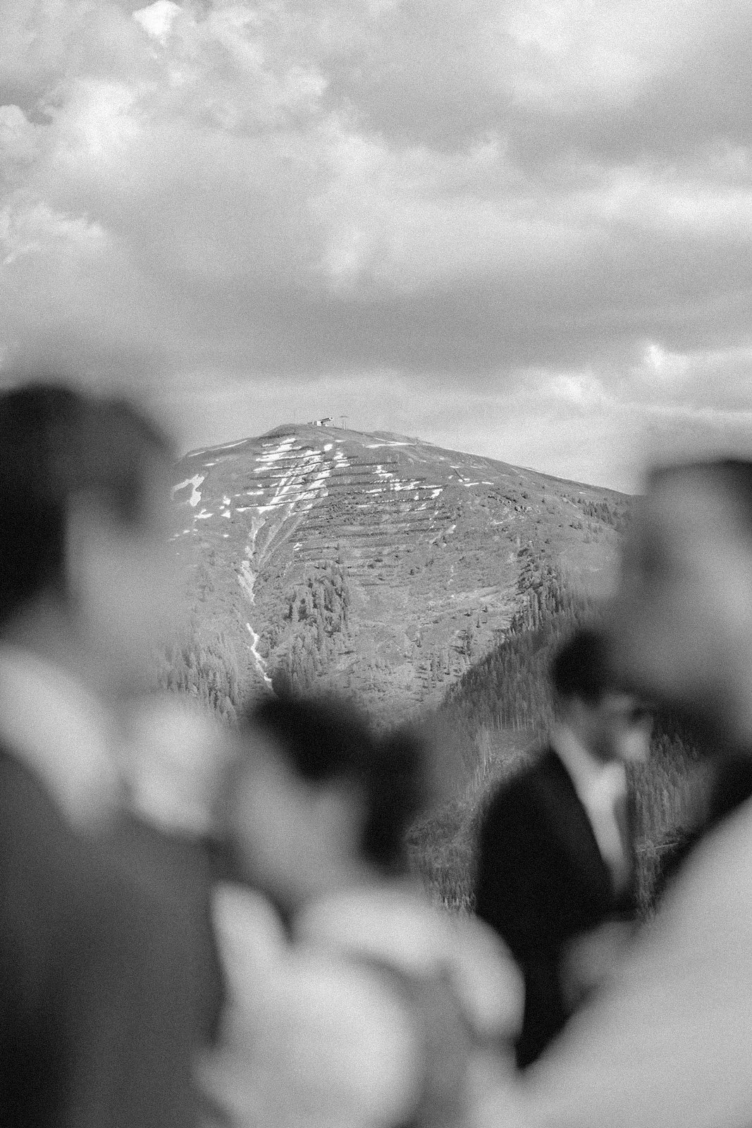 Eine schwarze und weiße Aufnahme einer Gruppe von Menschen, die einen Berg im Hintergrund betrachten.