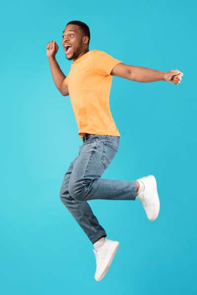 Homme joyeux sautant avec un cri sur un fond bleu