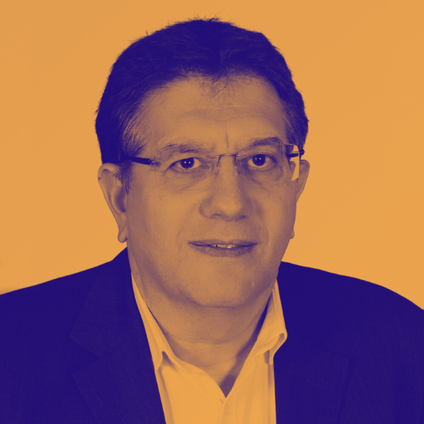 Portrait d'un homme portant des lunettes, en costume et chemise, avec un fond orange