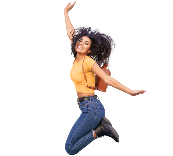 Femme souriante sautant en l'air avec un sac à dos, portant un t-shirt jaune et un jean.