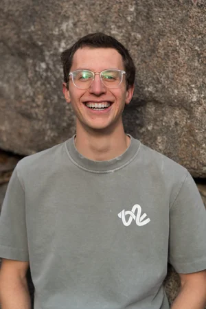 Portrait of Jackson Wetherill in front of a sandstone boulder