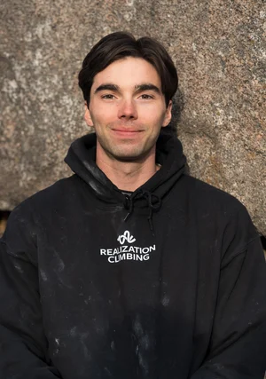 Portrait of Kieran Hadley in front of a sandstone boulder