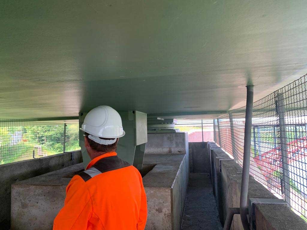 Ingenieur bei der Bauwerksprüfung unter der Levensauer Hochbrücke mit Blick auf Lager und Unterkonstruktion – Bauwerksprüfung im Brückenbau.