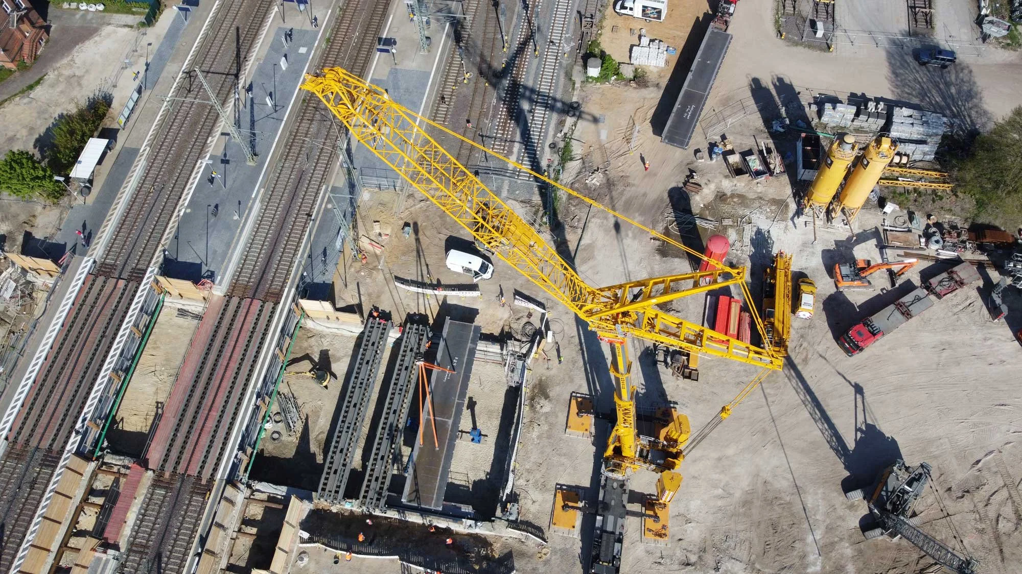 Luftaufnahme einer Brückenbaustelle an Bahngleisen in Ludwigslust mit Mobilkran beim Einheben von Brückenelementen im Ingenieurbau.