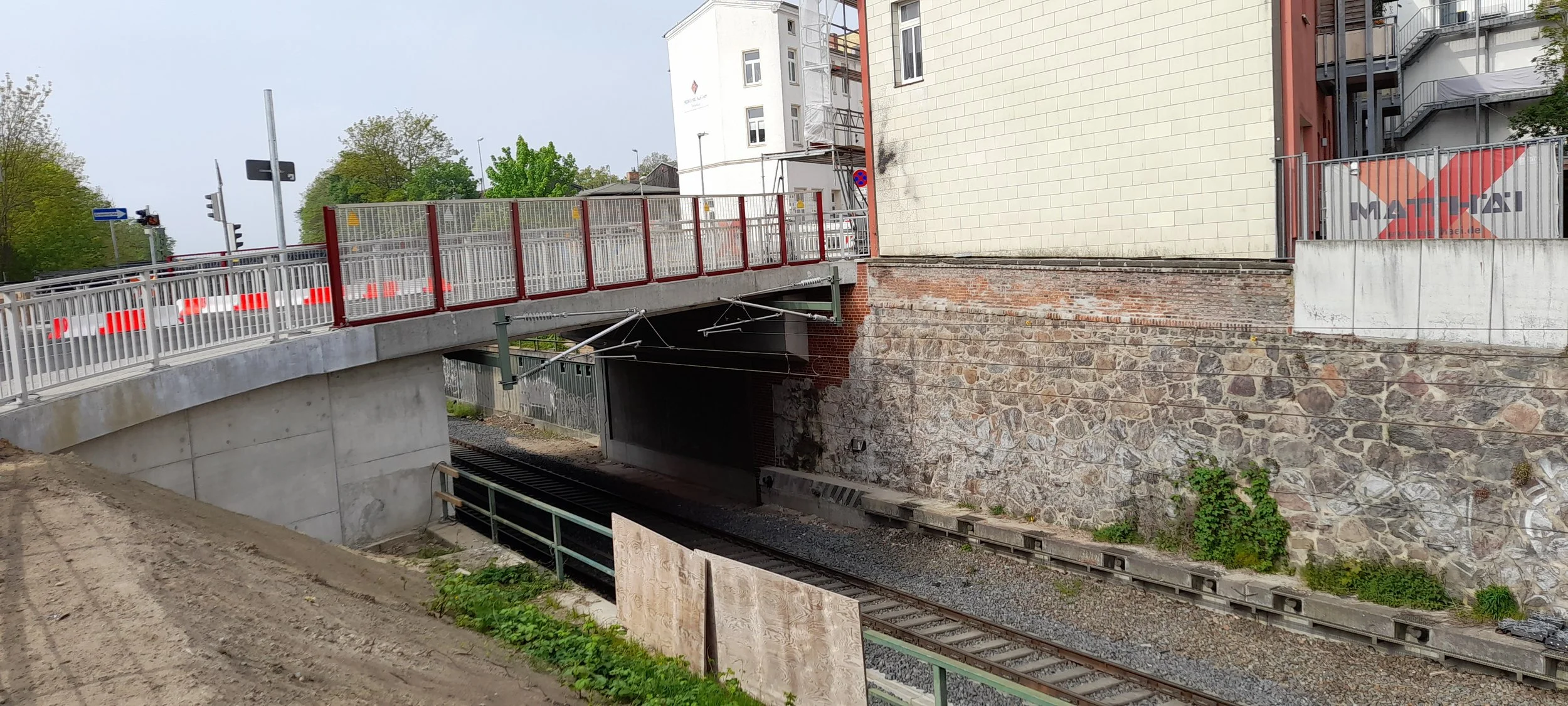Bauüberwachung an der Wallstraßenbrücke Schwerin: neu hergestellte Brückenkonstruktion über Gleisanlagen mit angrenzender Bestandsmauer im Rahmen der Bauoberleitung im innerstädtischen Brückenbau.