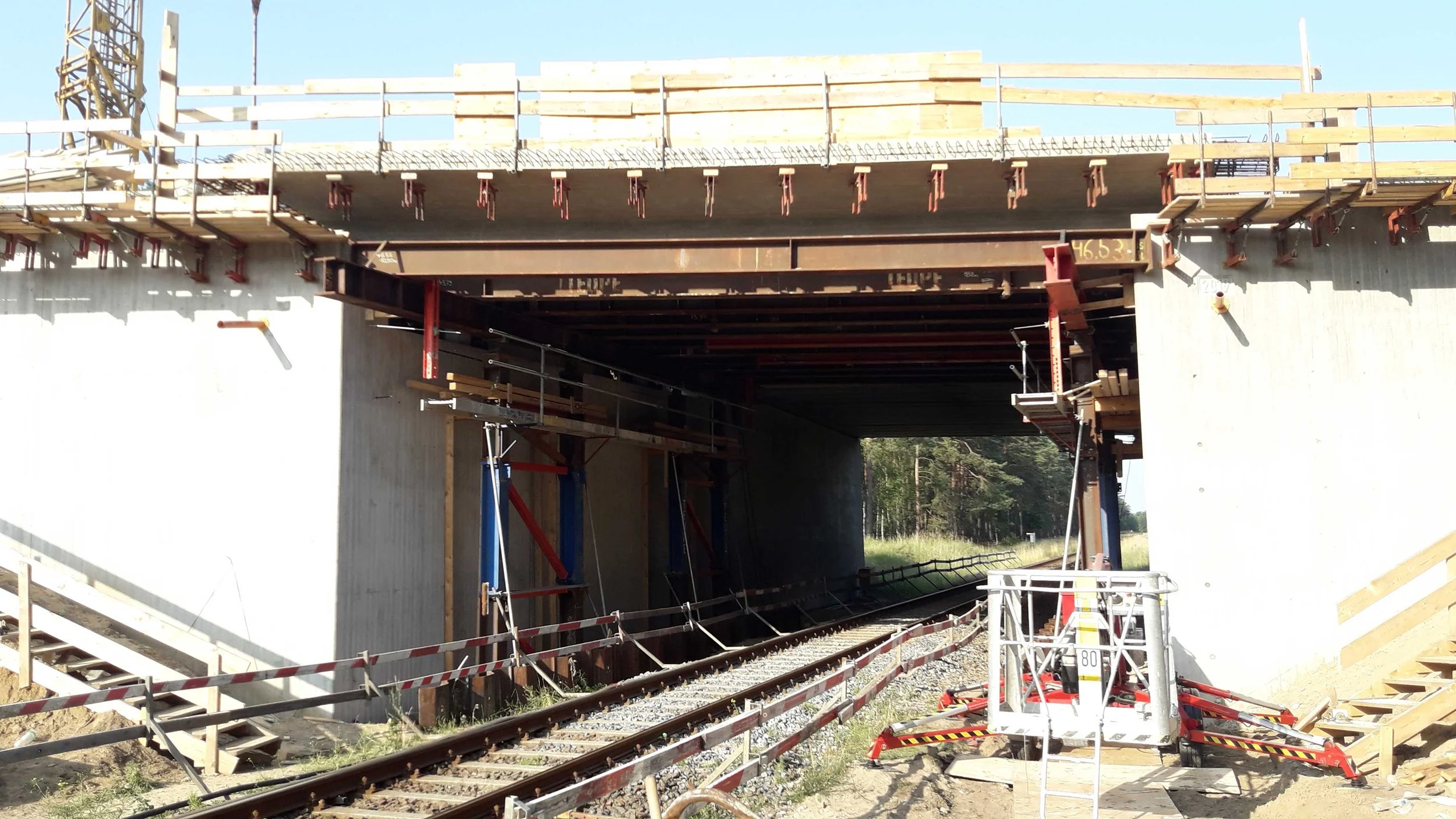 Eisenbahnüberführung im Brückenbau während des Ausschalens des Überbaus, mit Gleisen unter der Brücke und Bauarbeiten, umgesetzt durch ein Ingenieurbüro wie Brückenköpfe Schwerin.