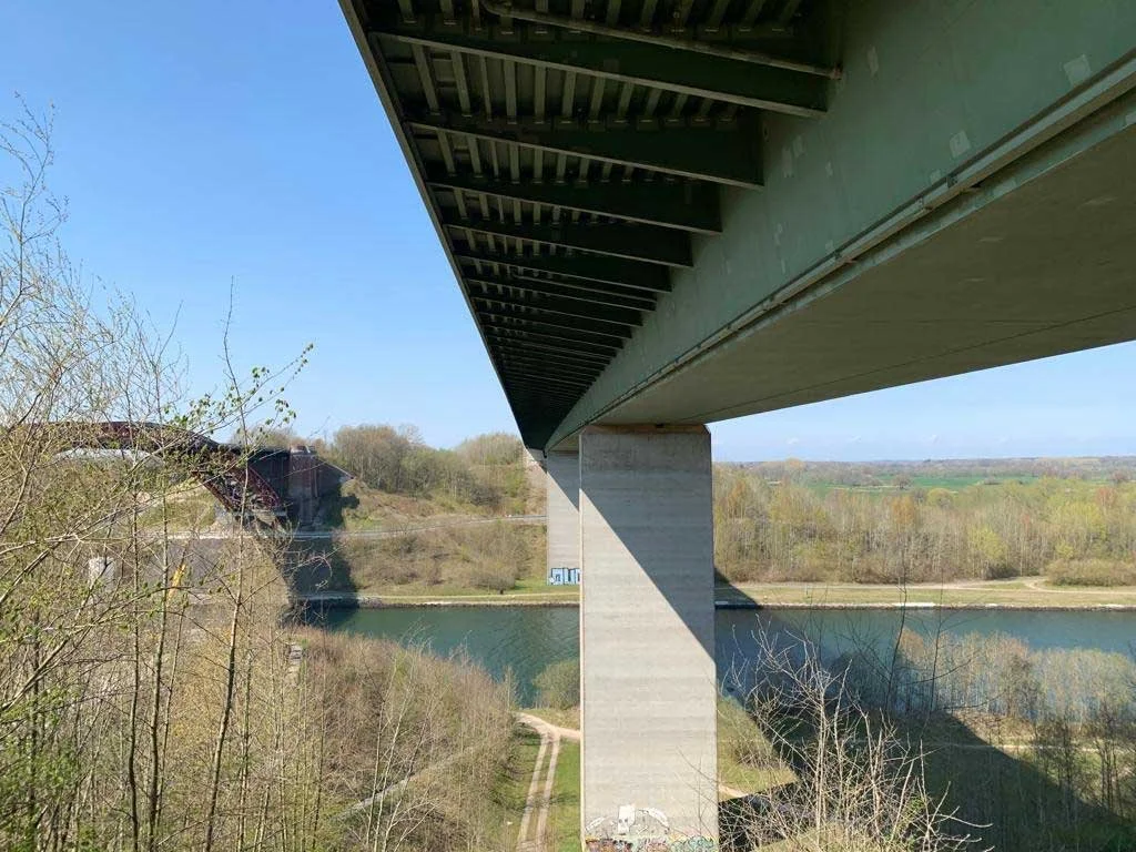 Unteransicht der Levensauer Hochbrücke mit Stahlüberbau und Betonpfeiler über dem Nord-Ostsee-Kanal – Tragwerkskonstruktion im Brückenbau.