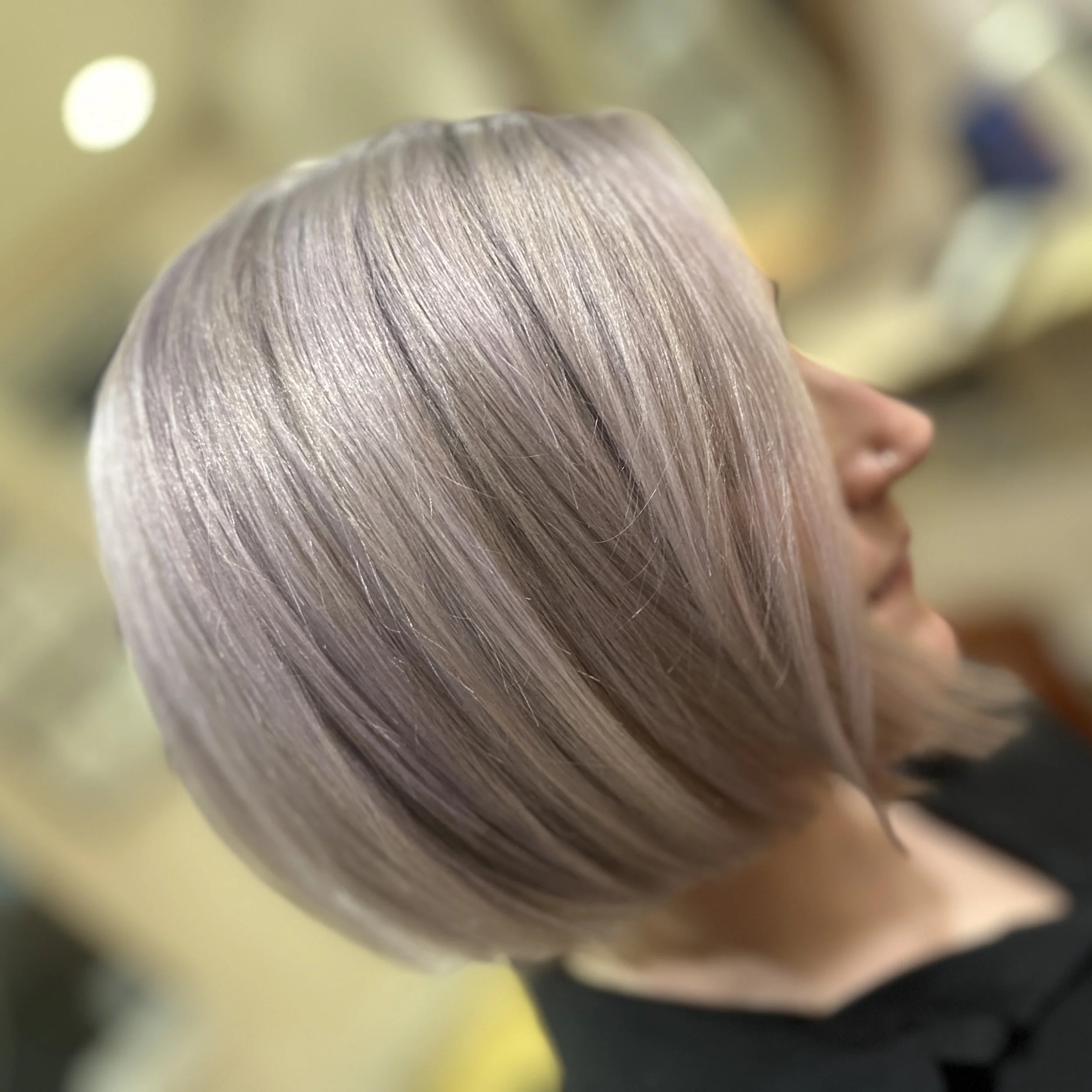 Side view of a woman with short, straight, silver-blonde hair.