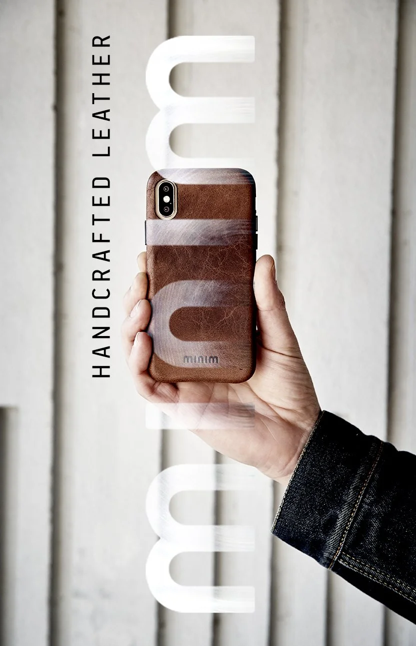 Hand houdend smartphone met bruin lederen hoesje en tekst 'Handcrafted Leather' en 'minim' op achtergrond.