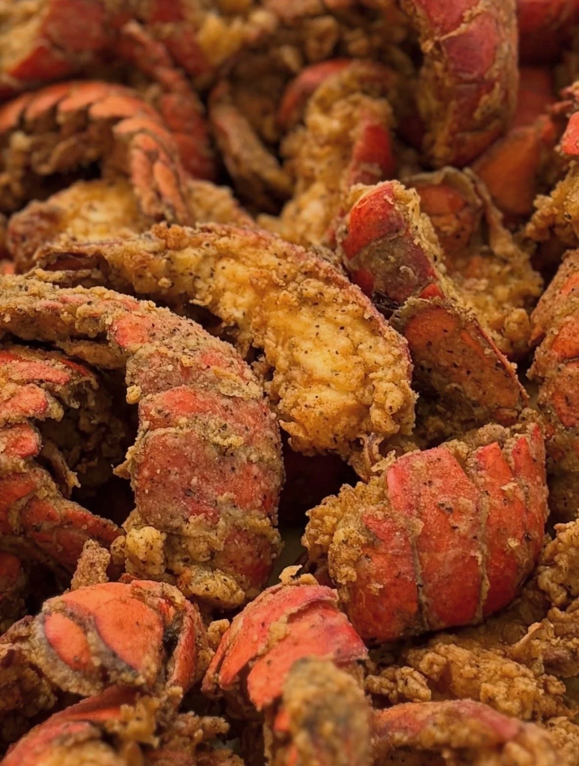 Close-up of cooked lobster claws covered with seasoned breading.