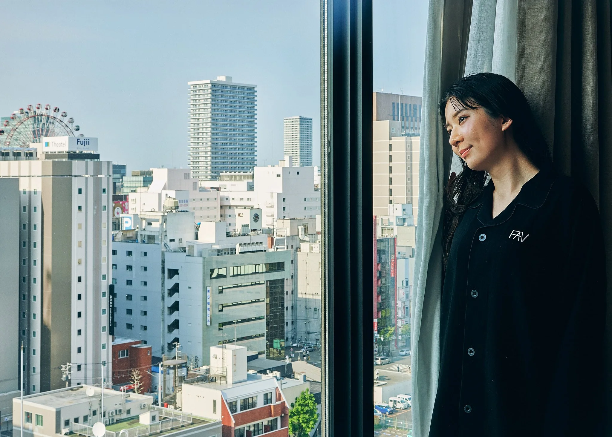 Guest standing by window inside hotel room