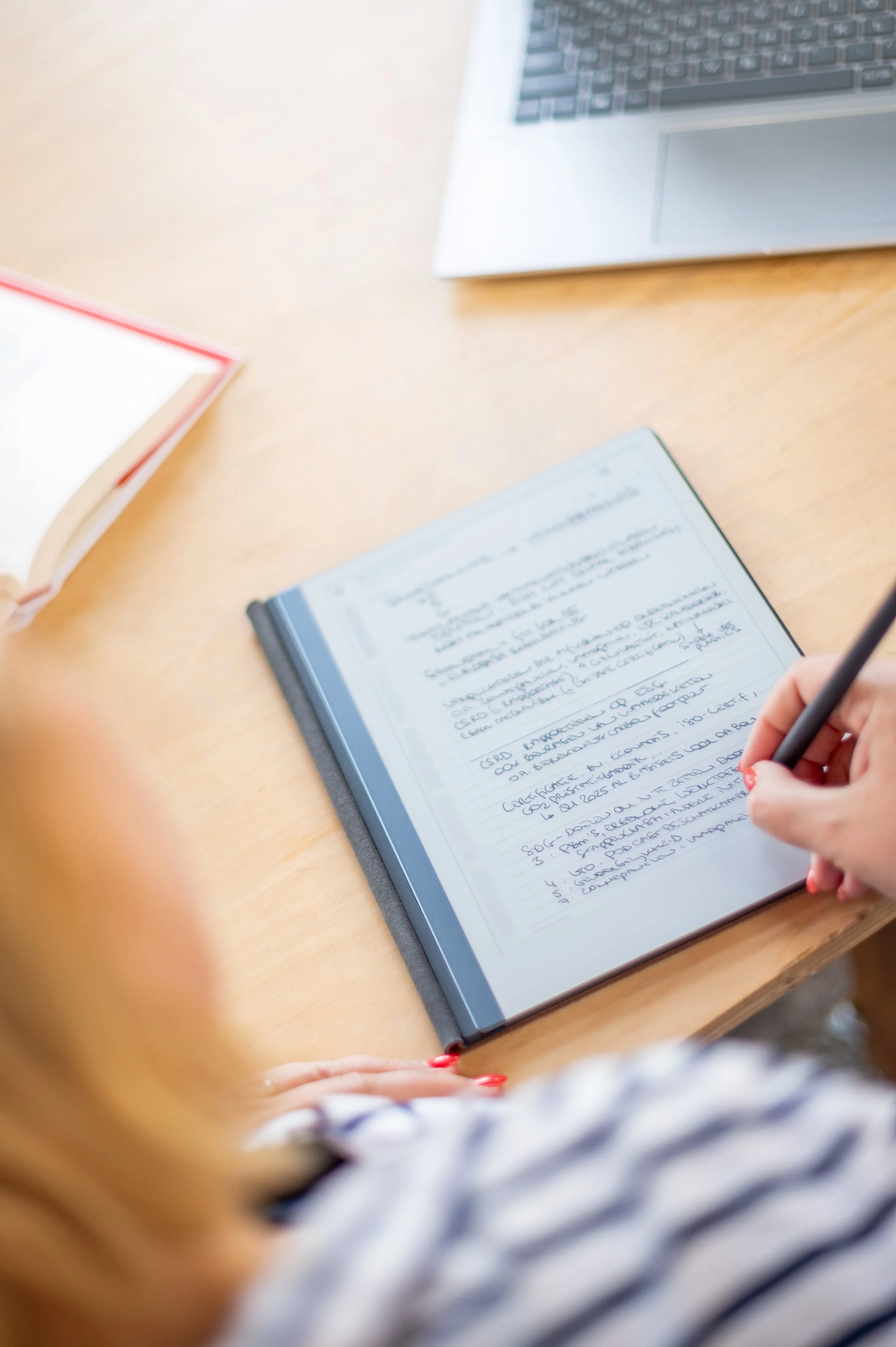 Elke Mertens, onafhankelijk archeologisch adviseur. Op de foto zie je haar aantekeningen maken in haar Remarkable-tablet op een houten tafel.