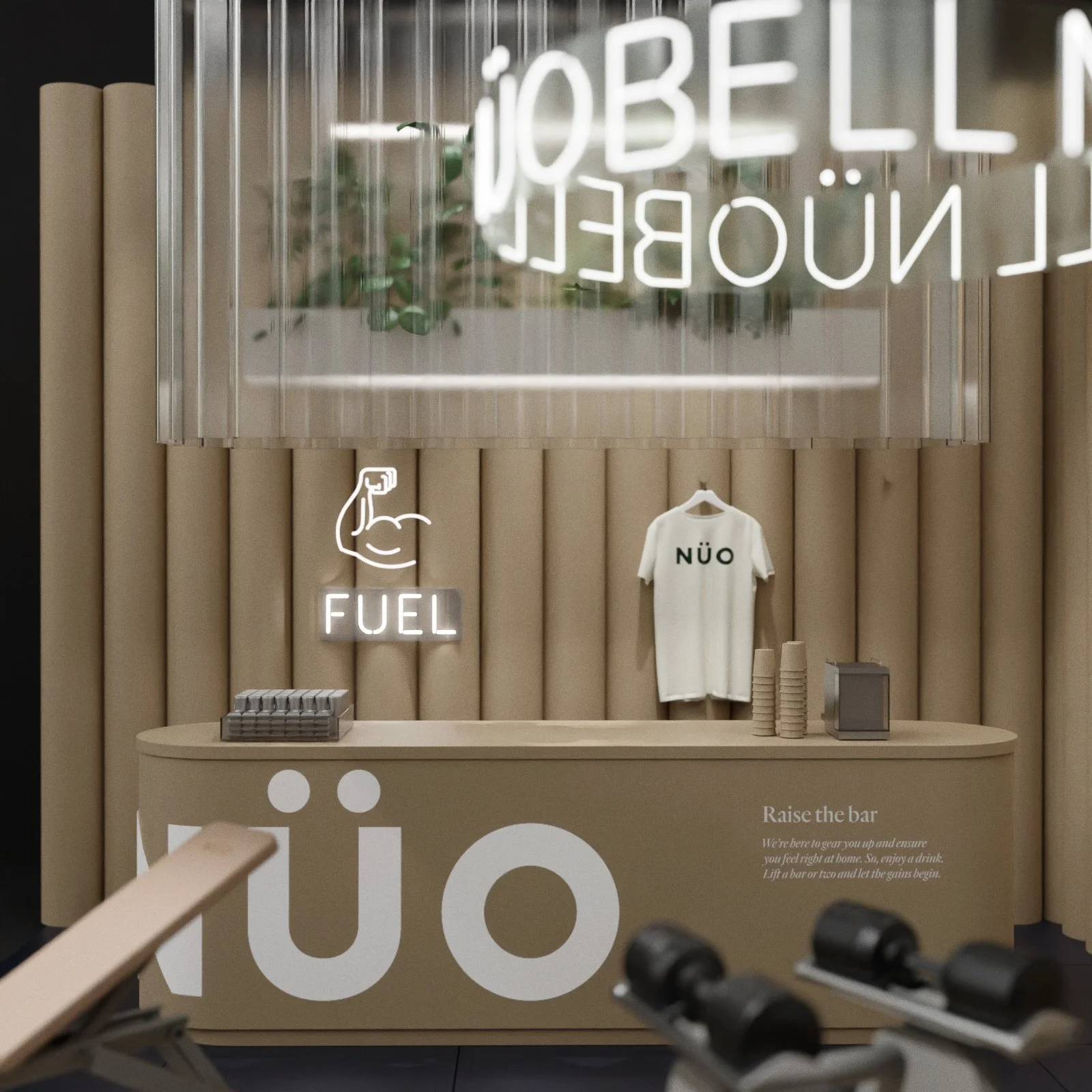A fitness-themed display with neon signs reading 'FUEL' and 'JÖBEL'. A white T-shirt with 'NÜØ' printed on it hangs on the wall. The display features beige padded wall panels, a beige counter with large white letters, and gym equipment in the foregro