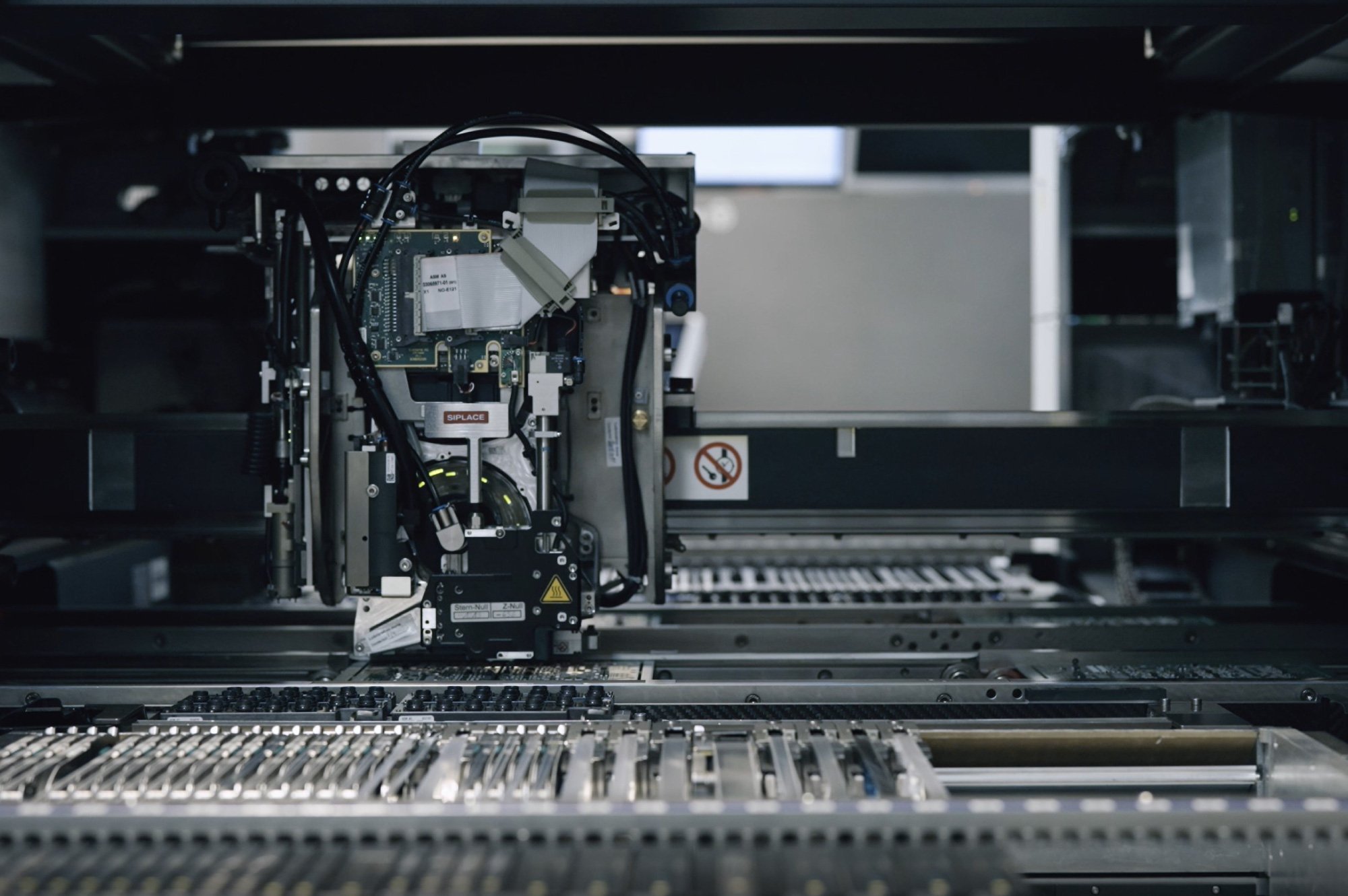 Close-up view of a high-tech machine or robotic assembly line in a modern factory, with various metallic components and wiring.