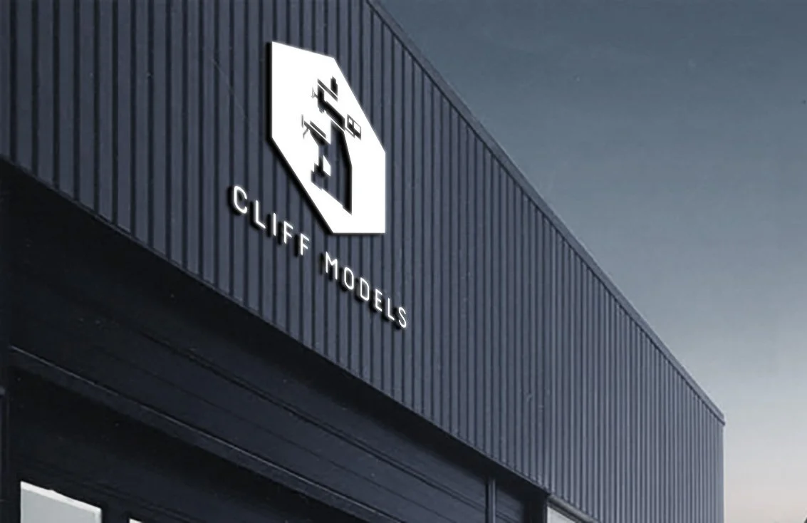 Close-up of the exterior of Cliff Models building with a sign of a pixelated face logo.