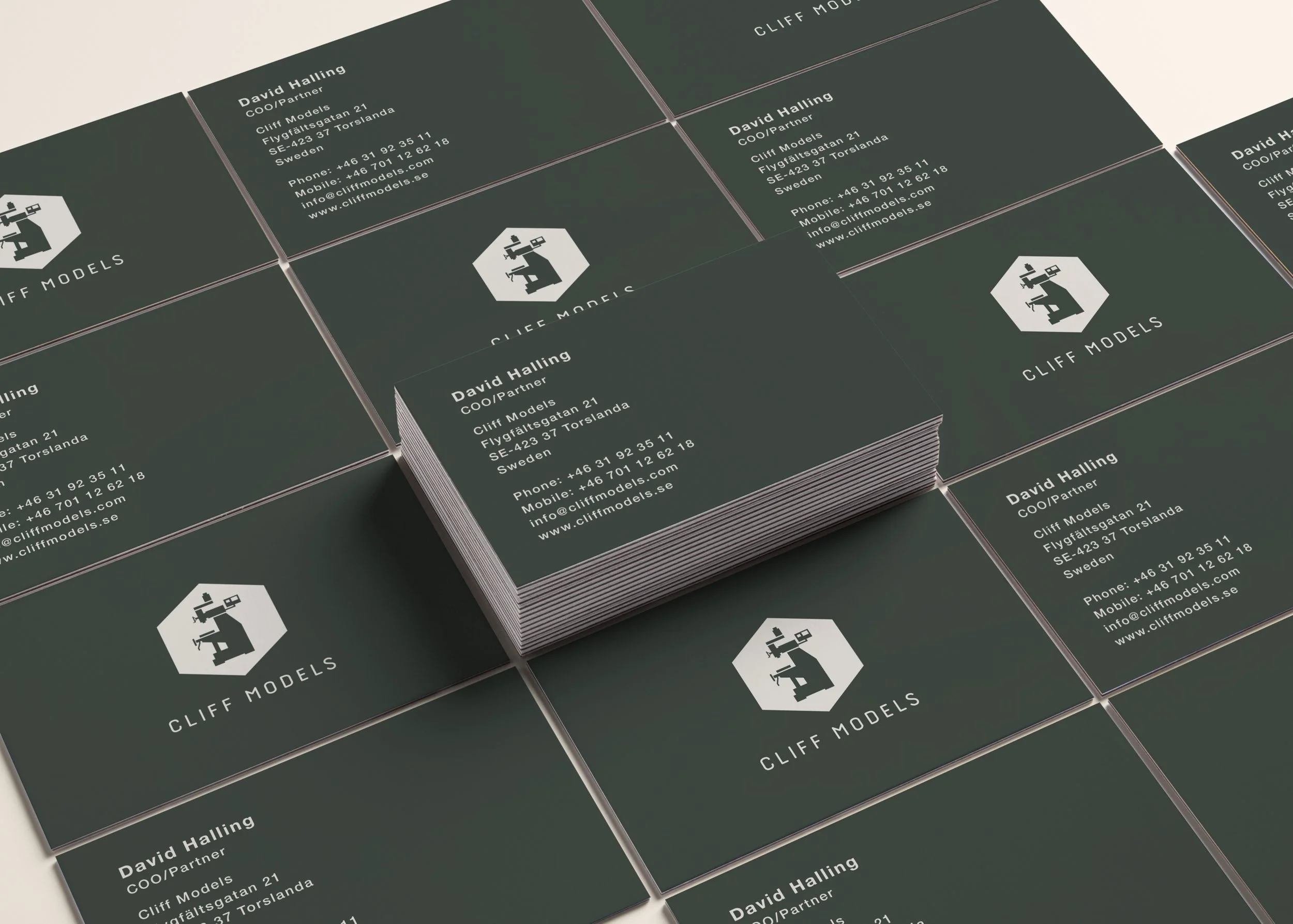 Stack of business cards for Cliff Models featuring contact information for David Halling, COO/Partner, with a logo of a person sitting at a desk with a computer.