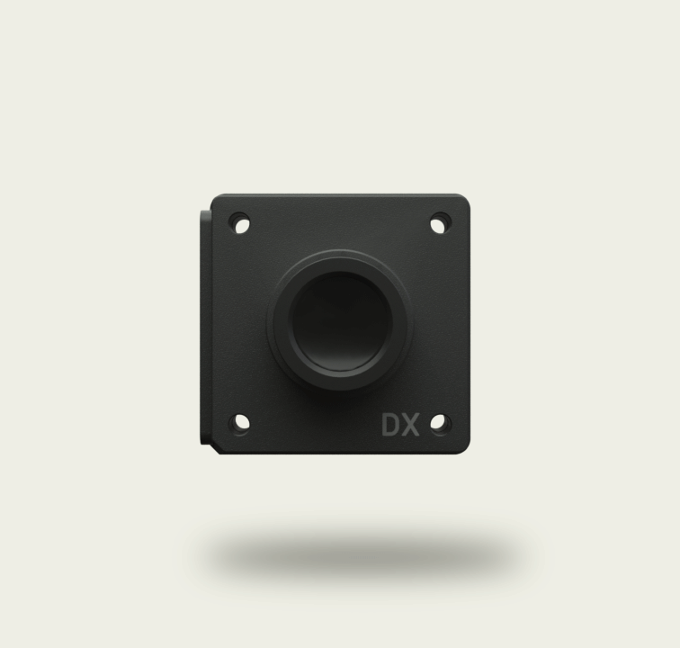 Black square camera lens mount with four screw holes and the letters DX on the bottom right.