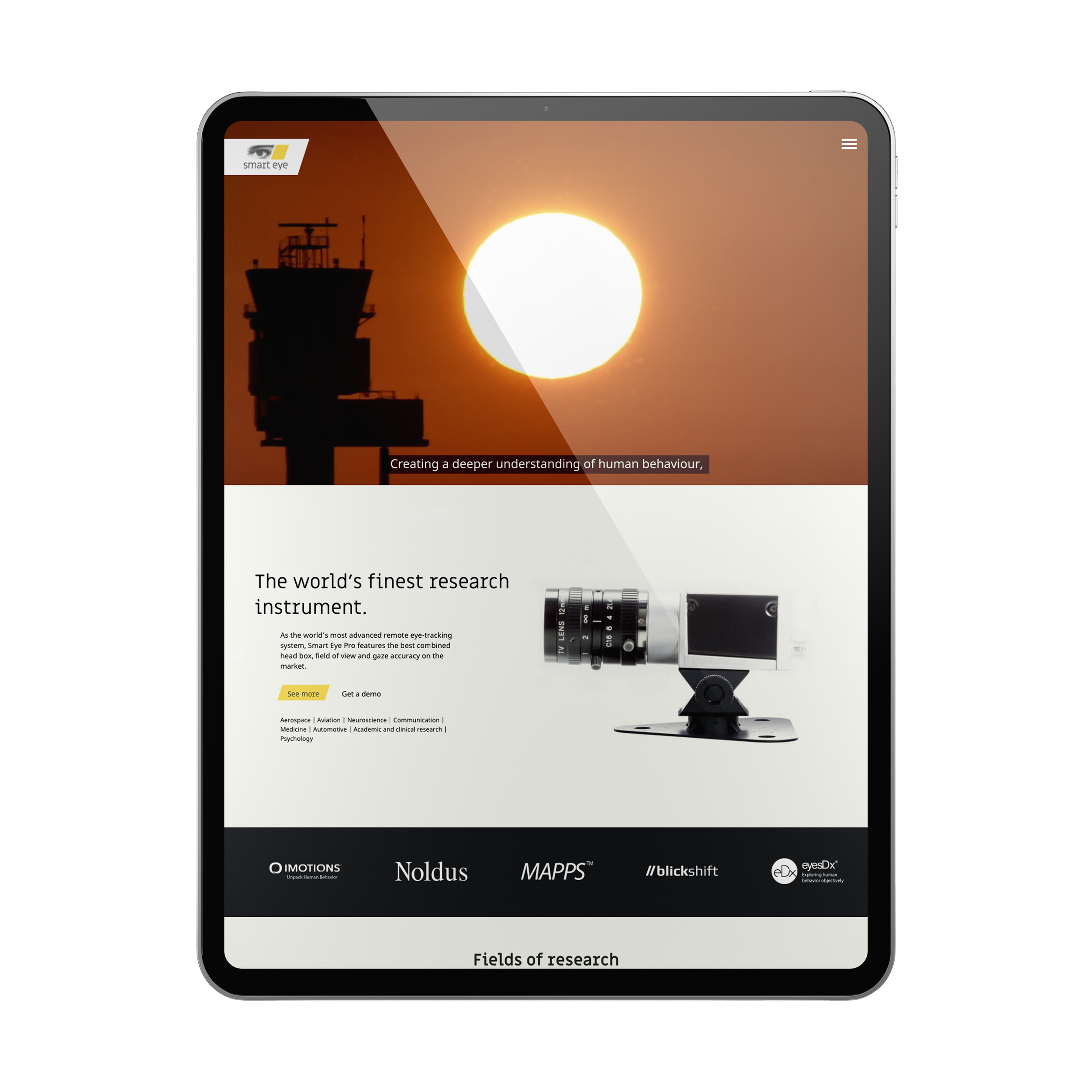 Tablet displaying a website about research instruments, with a sunset or sunrise scene and a silhouette of a control tower in the background.