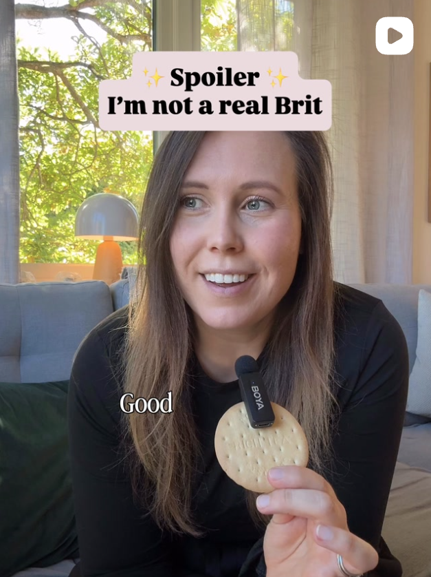 Woman sitting on a sofa holding a biscuit and talking