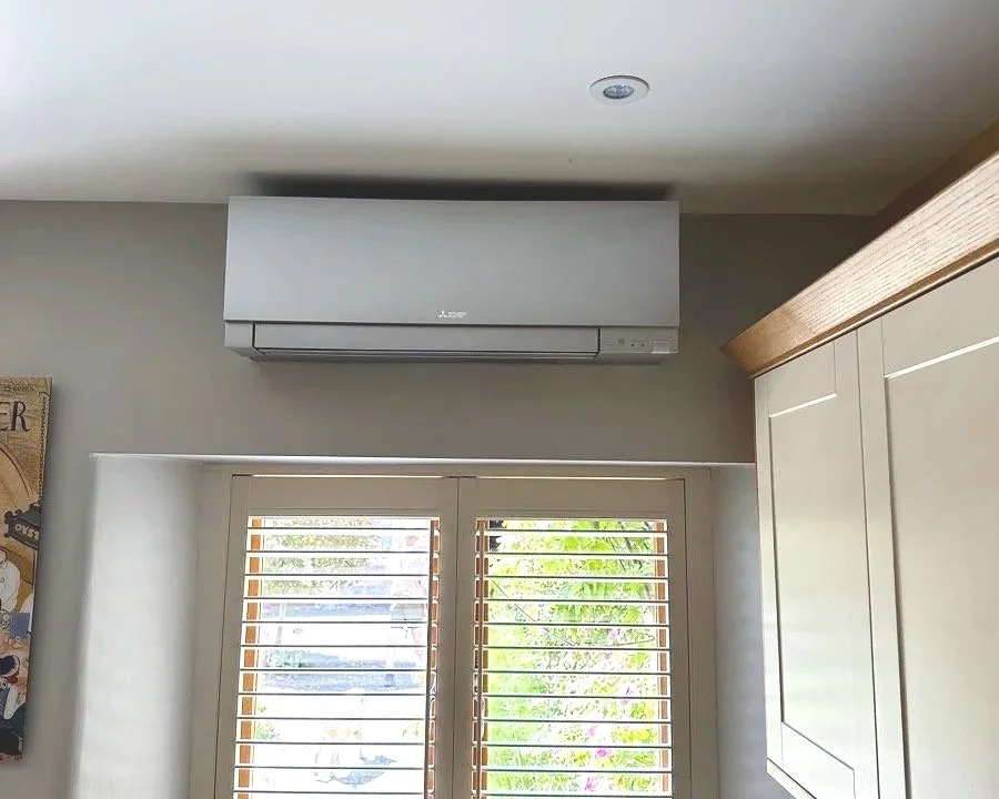 Room interior with window, wooden blinds, and wall-mounted air conditioner