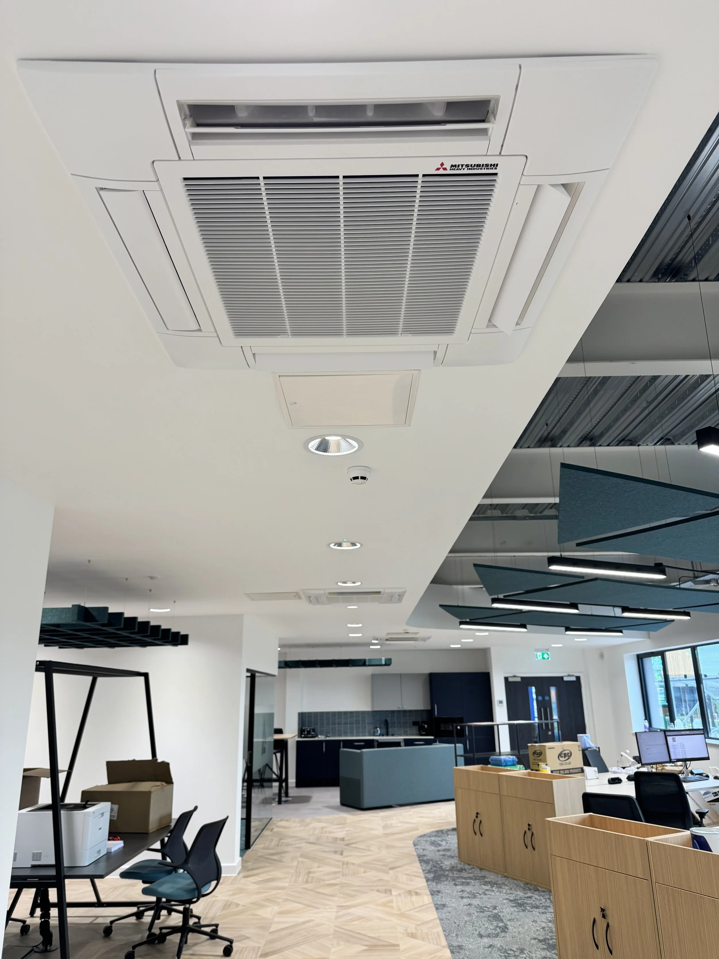 Ceiling-mounted Mitsubishi air conditioning unit in a modern office space.