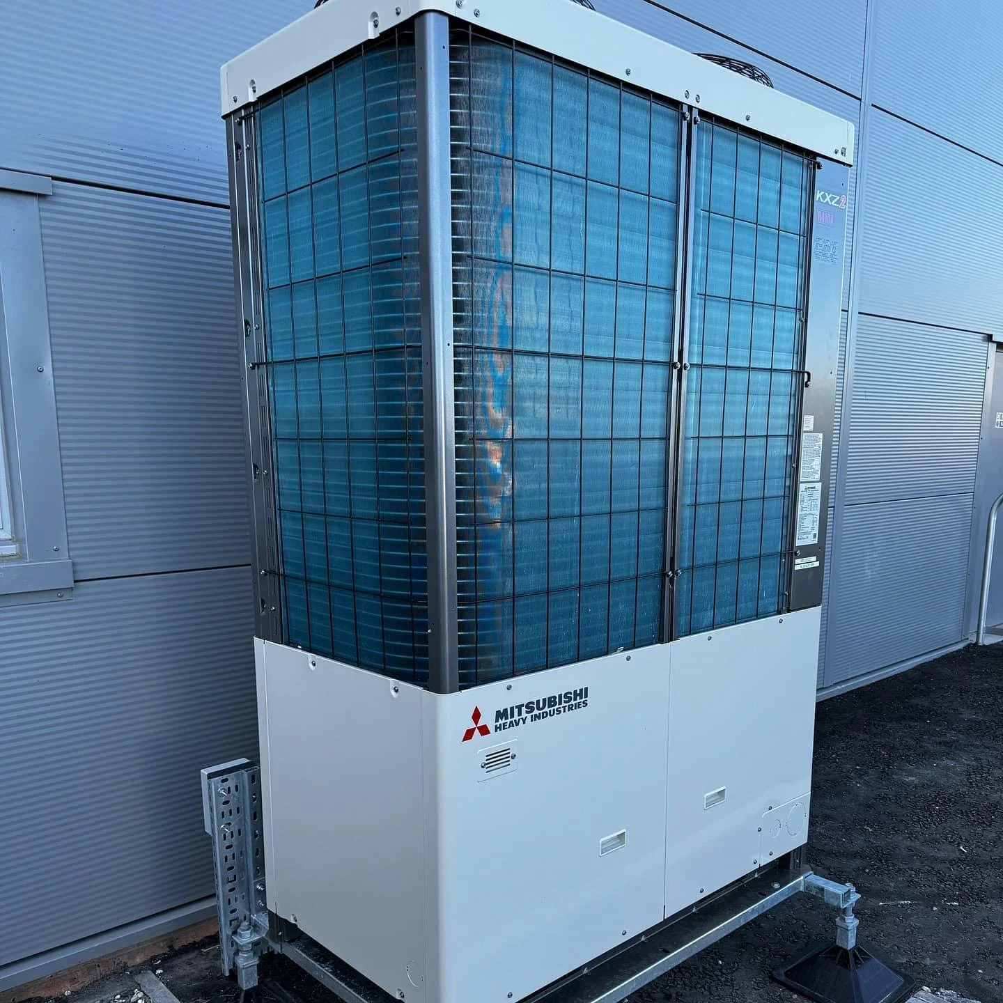 Outdoor Mitsubishi Heavy Industries HVAC unit on a metal stand at an industrial or commercial building.