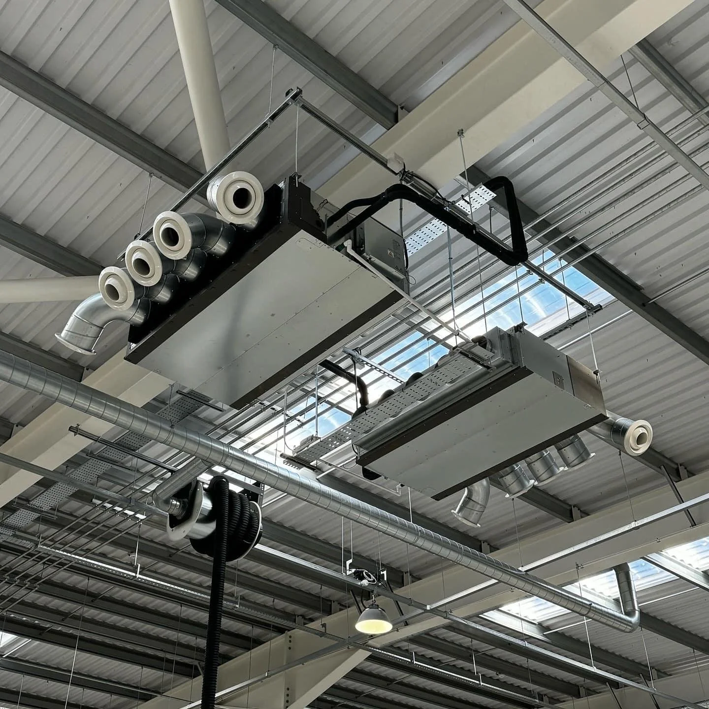 Ceiling-mounted HVAC units and ductwork in an industrial or commercial building