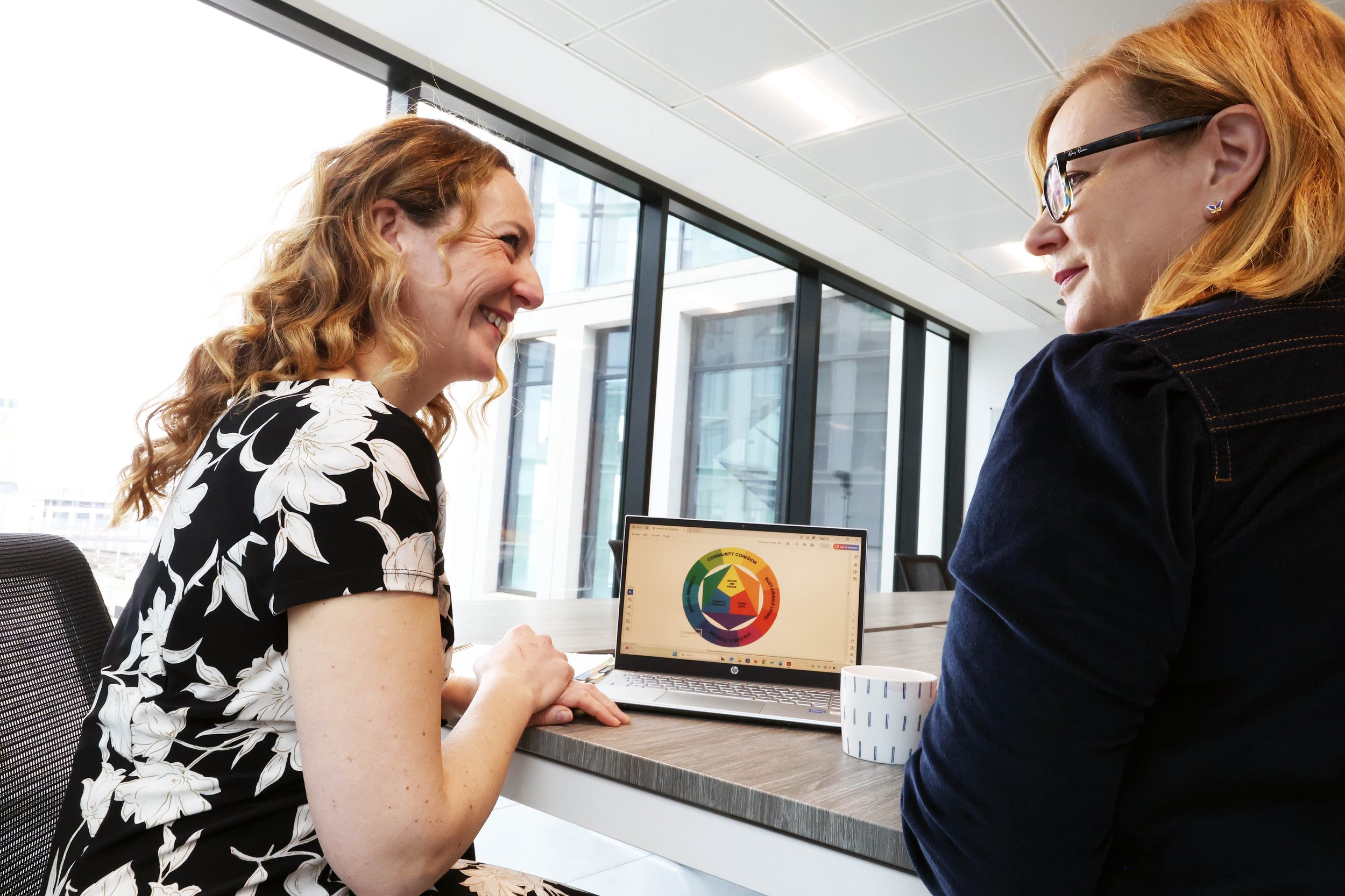 People sitting in rows at a conference, taking notes in notebooks.