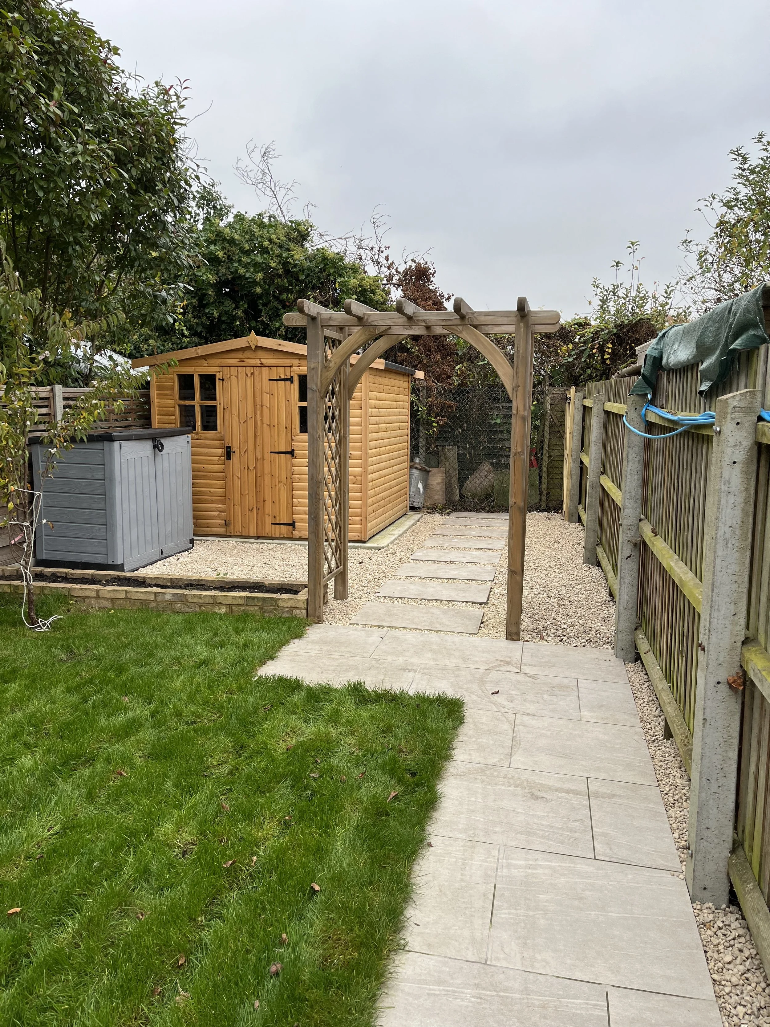 arched pergola installation with gravel and porcelain steps in cambridge