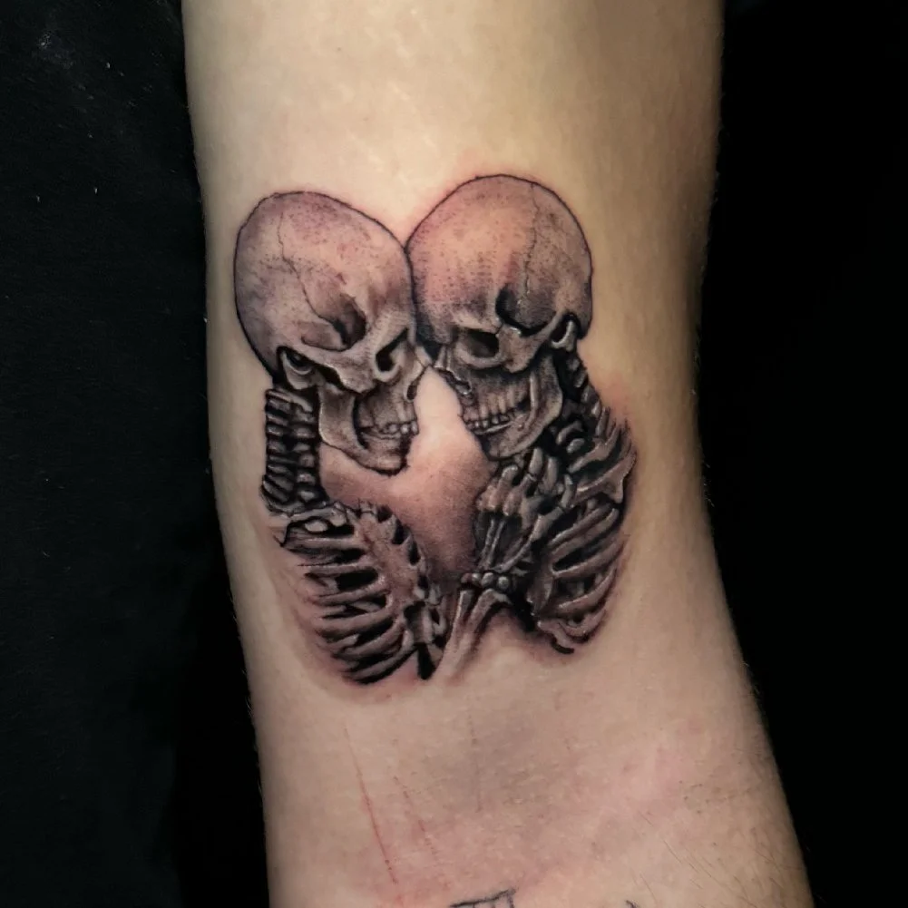Tattoo of two skeletons embracing.