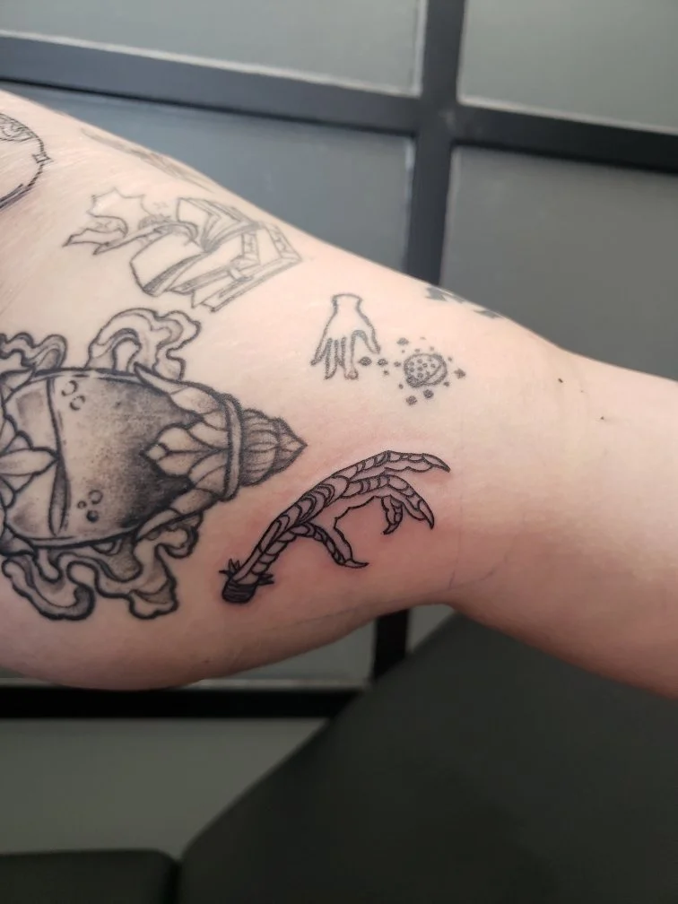 Tattoo of a chicken's foot in a modern style.