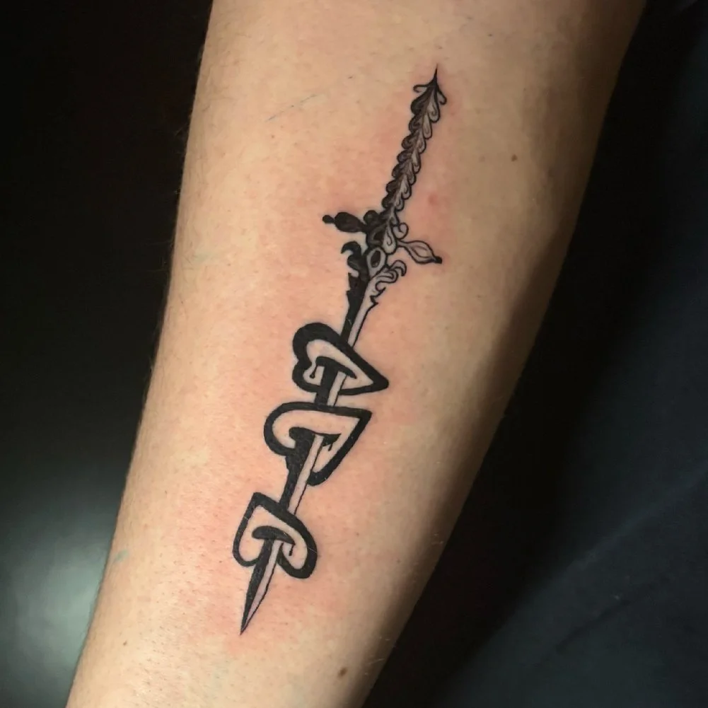 Tattoo of a sword piercing three hearts.